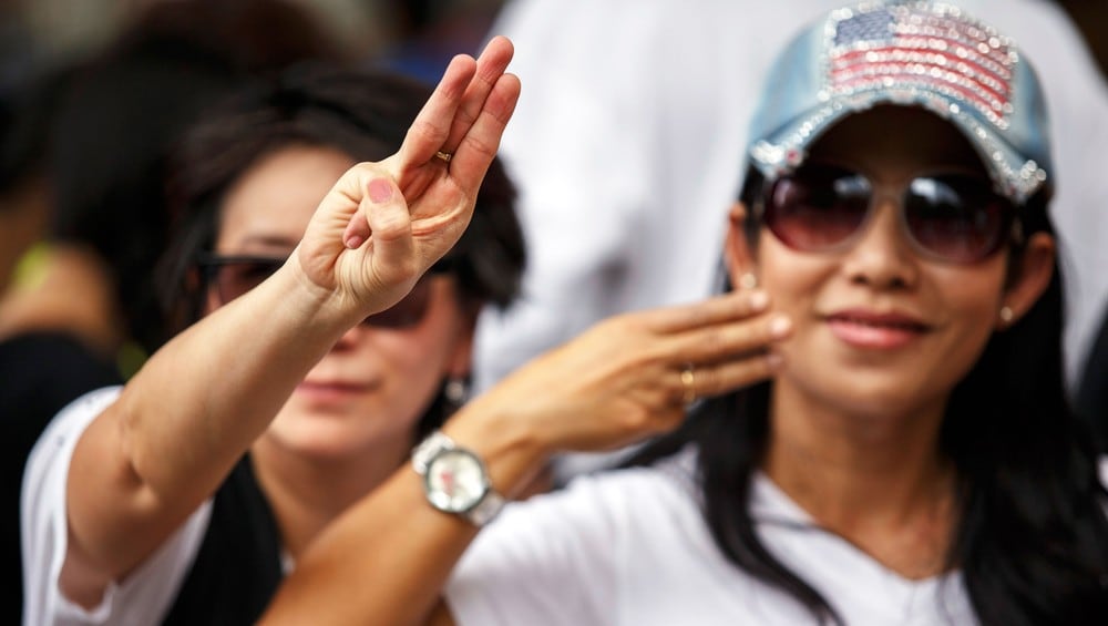 Demonstranter i Bangkok - To demonstranter utenfor den amerikanske ambassaden i Bangkok gjør det forbudte håndtegnet fra filmen The Hunger Games. - Foto: Athit Perawongmetha / Reuters