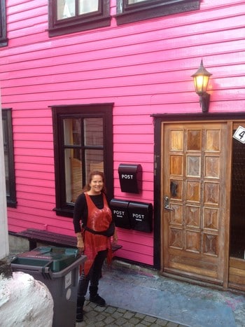 Hennie Arling foran sitt rosa hus - – FRISKER OPP: – Fargen frisker opp og gjør det artigere å bo i dette strøket, sier Hennie Arling. - Foto: Hilde Crone Leinebø / NRK