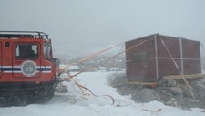 Hus og biler måtte tjores fast på Troll (Foto: Jan-Gunnar Winther/Norsk polarinstitutt) Hus og biler måtte tjores fast på Troll (Foto: Jan-Gunnar Winther/Norsk polarinstitutt)