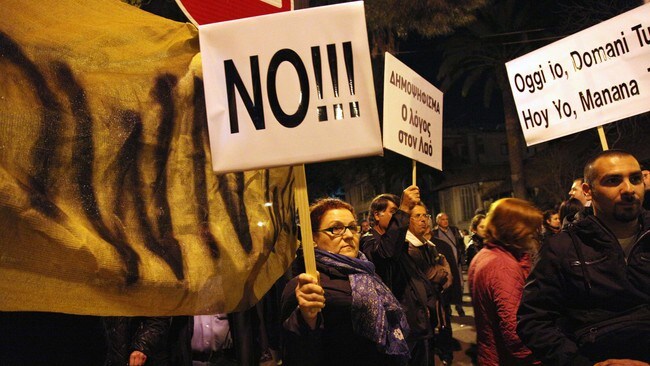 Kypriotiske demonstranter under en markering mot krisepakken utenfor nasjonalforsamlingen i Nicosia (Foto: BARBARA LABORDE/Afp) Kypriotiske demonstranter under en markering mot krisepakken utenfor nasjonalforsamlingen i Nicosia (Foto: BARBARA LABORDE/Afp)