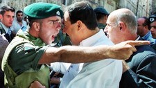 En israelsk soldat og en palestiner skriker til hverandre 13. oktober 2000 utenfor al-Aqsa-moskeen. (Foto: Stringer/Scanpix/Reuters)
