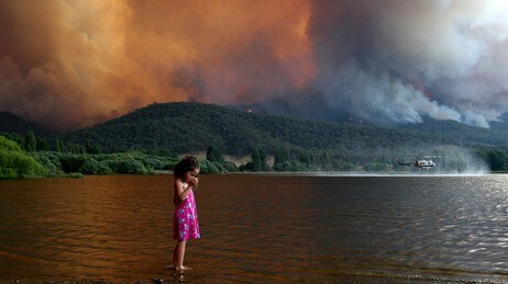 Vesle Milan Smith vasser i vannet mens det brenner i Mt. Beauty i Australia. (Foto: CHRIS HOCKING/AP) Vesle Milan Smith vasser i vannet mens det brenner i Mt. Beauty i Australia. (Foto: CHRIS HOCKING/AP)