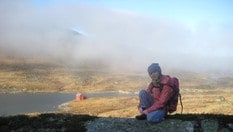 Øvre Sandvatn i Saudafjella bader i sol i bakgrunnen. Mari Amdal er på veg heim etter overnatting i høstferien