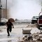 En mann løper i dekning i Aleppo.