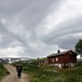 Mann med stor ryggsekk går mot Jøldalsbua i Trollheimen