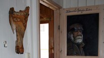 Fyrforvalter Andreas Mølbach er malt på en dør på Lindesnes fyr. Trebeinet hans henger på veggen.  (Foto: Ann Eli Nøsen/NRK)