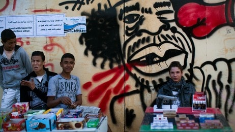Gateselgere venterpå kunder foran en tegning av gaddafi i Benghazi (Foto: Rodrigo Abd/Ap) Gateselgere venterpå kunder foran en tegning av gaddafi i Benghazi (Foto: Rodrigo Abd/Ap)