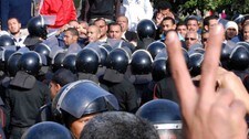 Demonstrant viser V-tegnet foran politi i Suez (Ap) Demonstrant viser V-tegnet foran politi i Suez (Ap)