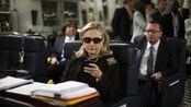 Hillary Clinton i det hun ser på telefonen sin ombord på et fly (Foto: KEVIN LAMARQUE/Afp)