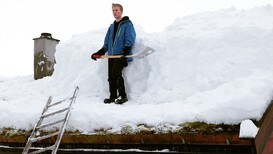 Måker snø av hyttetaket - Foto: Eirik Kindingstad