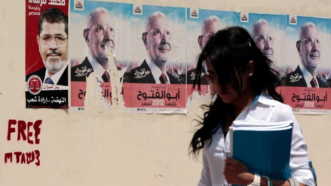 Ei kvinne i Kairo går forbi valplakat til Mohamed Mursi (Foto: AMR ABDALLAH DALSH/Reuters) Ei kvinne i Kairo går forbi valplakat til Mohamed Mursi (Foto: AMR ABDALLAH DALSH/Reuters)