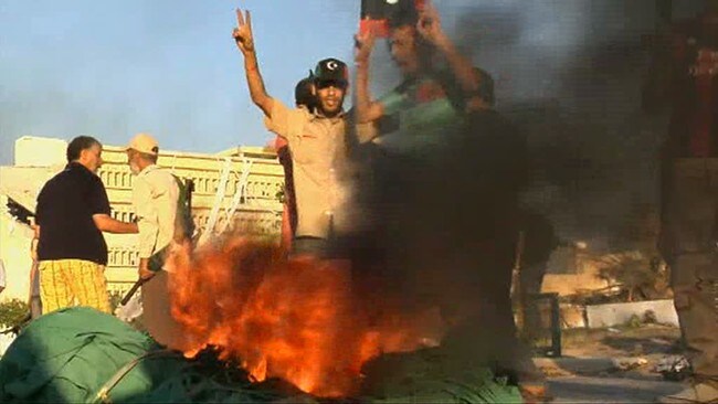 Opprørere brenner Gaddafi-regimets flagg. (Ap) Opprørere brenner Gaddafi-regimets flagg. (Ap)