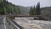 Bru tatt av flom  - Gårdbruker Roar Aasen i Åsengrenda i Haltdalen har brukt gravemaskin for å grave unna grusmassene og slippe vannet  forbi, slik at ikke brua skal få hele trykket, sier Aasen. 