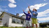 Nora og Kornelius lar vinden blåse såpebobler på Hemnesberget