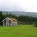 Bak stua står en gammel låve. Dette bildet deltok i Fotokonkurranse sommer 2009