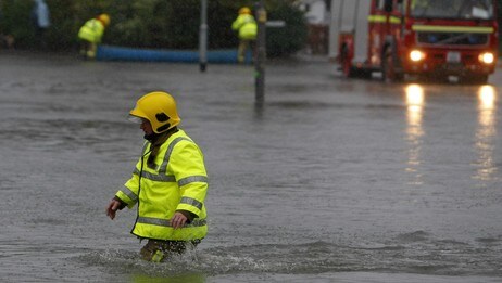 En brannmann vasser gjennom flomvann i Keswick i det nordlige England. (Foto: Phil Noble/Scanpix/Reuters)