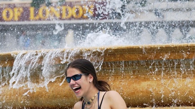 En kvinne kjøler seg ned på Trafalgar Square i London. (Foto: Arkivfoto: Adam Butler/Scanpix/AP)