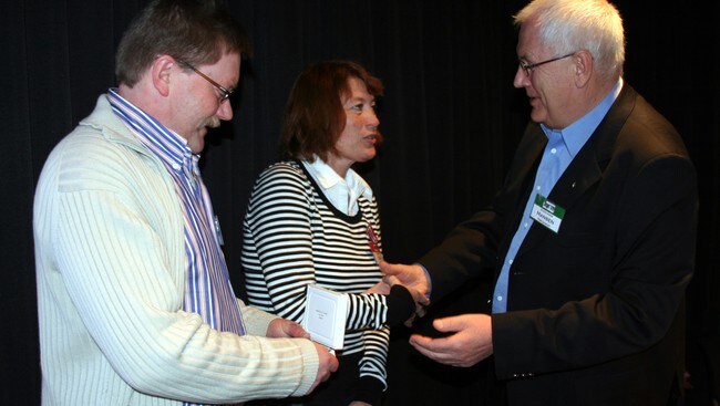 Rune og Oddfrid Osa får utmerkinga frå friidrettspresident Svein Arne Hansen. (Foto: Oddleif Løset/NRK)