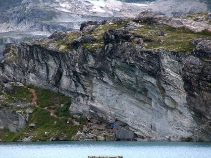 Fieldfarehytta er godt kamuflert under en berghammer.