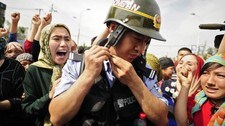 En kinesisk politimann blant demonstranter i regionhovedstaden Urumqi i Xinjiang i juli 2009. (Foto: Peter Parks/Scanpix/AFP) En kinesisk politimann blant demonstranter i regionhovedstaden Urumqi i Xinjiang i juli 2009. (Foto: Peter Parks/Scanpix/AFP)