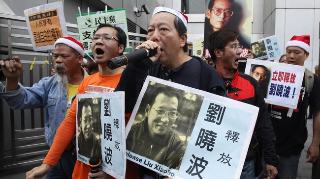 Demonstranter protesterer mot fengslingen av Liu Xiaobo (Foto: Kin Cheung/Scanpix/AP) Demonstranter protesterer mot fengslingen av Liu Xiaobo (Foto: Kin Cheung/Scanpix/AP)