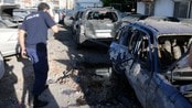 En politimann inspiserer rakettskadde biler i Beirut