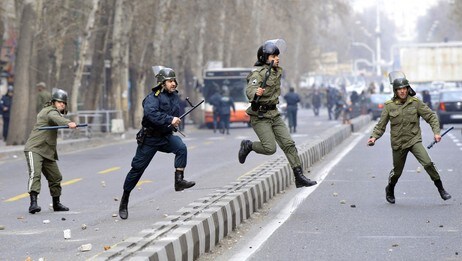 Iranian riot policemen run after opposition supporters (not seen) during clashes in Tehran on Decemb (Scanpix/AFP)