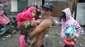 En familie blir evakuert til sikkerhet i Manila