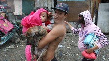 En familie blir evakuert til sikkerhet i Manila (Foto: BULLIT MARQUEZ/Ap)