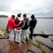 En gruppe sørgende ungdommer tenner lys og legger ned blomster på brygga ved Utvika Camping søndag ettermiddag for ofrene etter massakeren på Utøya, som ses i bakgrunnen.