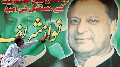 En tilhenger vasker plakaten av den tidligere avsatte statsministeren Nawaz Sharif