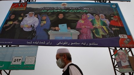 En mann i Kabul går under en reklameplakat som oppfordrer folk til å stemme ved valget. (Foto: Musadeq Sadeq/Ap) En mann i Kabul går under en reklameplakat som oppfordrer folk til å stemme ved valget. (Foto: Musadeq Sadeq/Ap)