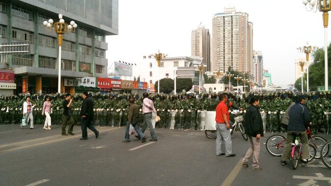 Opprørspoliti sperrer av gater i byen Urumqi i Xinjiang-regionen. (Foto: Andy Wong/AP)