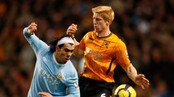 Manchester Citys Carlos Tevez i duell med Hulls Paul McShane.