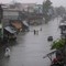 Innbyggerne stavrer seg gjenom en elv har gått over sine bredder i Navotas, nord for Manila.