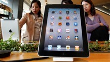 APPLE-SAMSUNG/AUSTRALIA Visitors look Apple iPad 2 tablets in Seoul (Foto: JO YONG-HAK/Reuters)