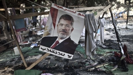 Et bilde av den avsatte presidenten Mohamed Morsi henger blant ruinene i protestleiren torsdag. (Foto: MAHMOUD KHALED/Afp) Et bilde av den avsatte presidenten Mohamed Morsi henger blant ruinene i protestleiren torsdag. (Foto: MAHMOUD KHALED/Afp)