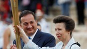 OLY-FLAME-ADV71 Britain's Princess Anne raises a torch with the Olympic Flame during an Olympic flame handover ceremony at the Panathenaic stadium in Athens