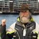 Lars Thomas Nordby / NRK Mann med langt skjegg, cowboyhatt, seilerjakke og flytevest med sjøen og Sørenga i bakgrunnen