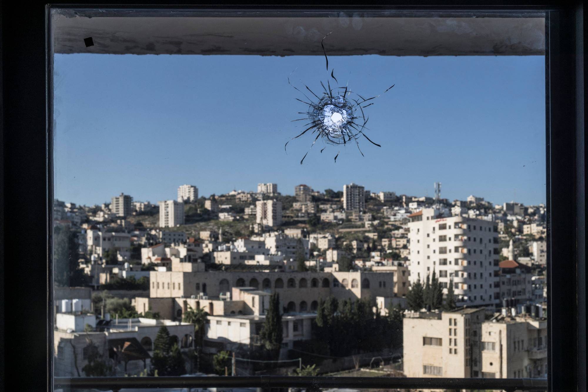 Et kulehull sees i et vindu i den palestinske byen Jenin på Vestbredden.