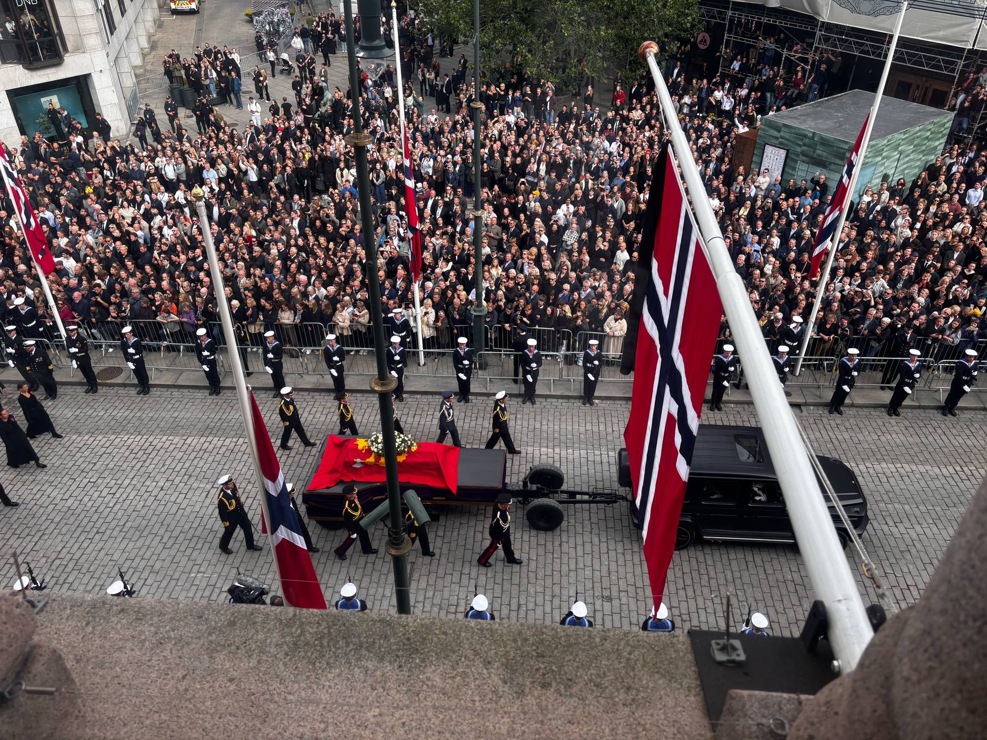 Sørgeprosesjonen med kong Haralds båre passerer Stortinget