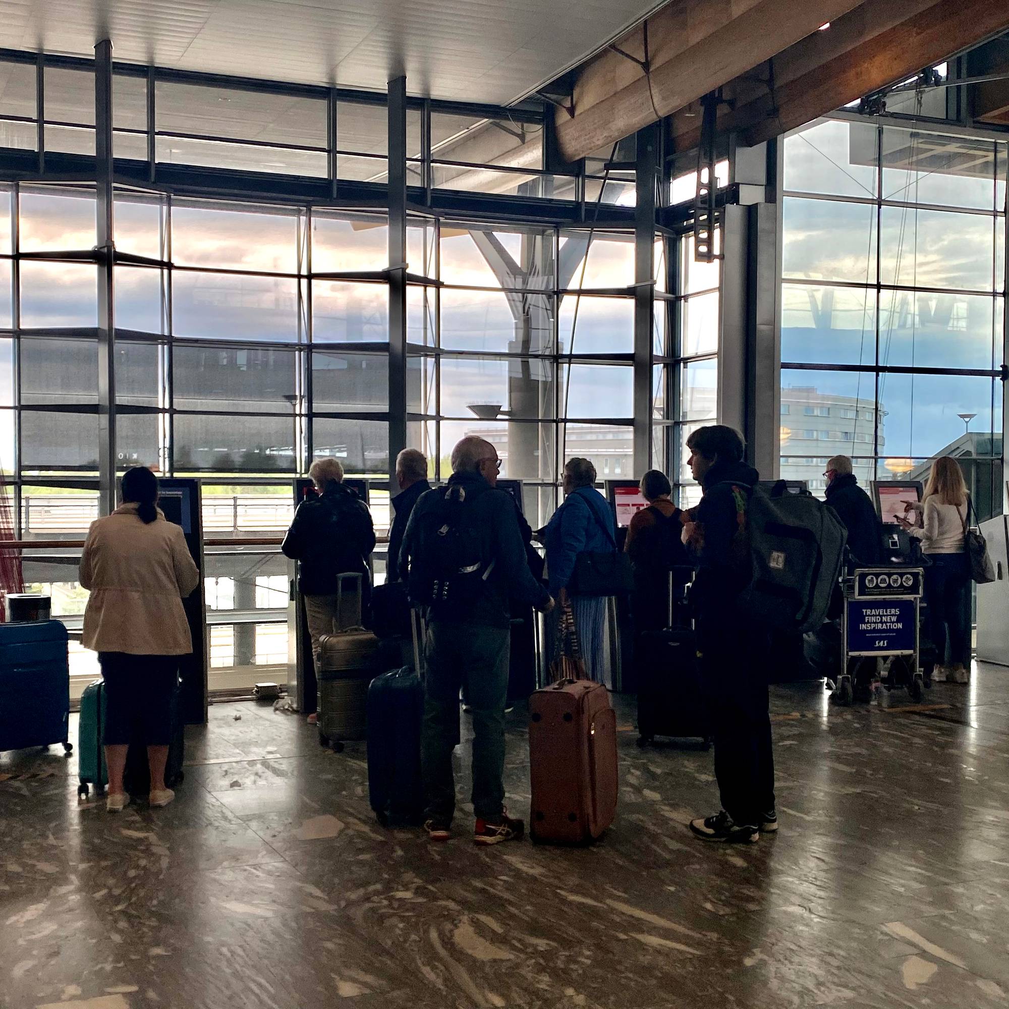Folk i innsjekk-kø på flyplass. 