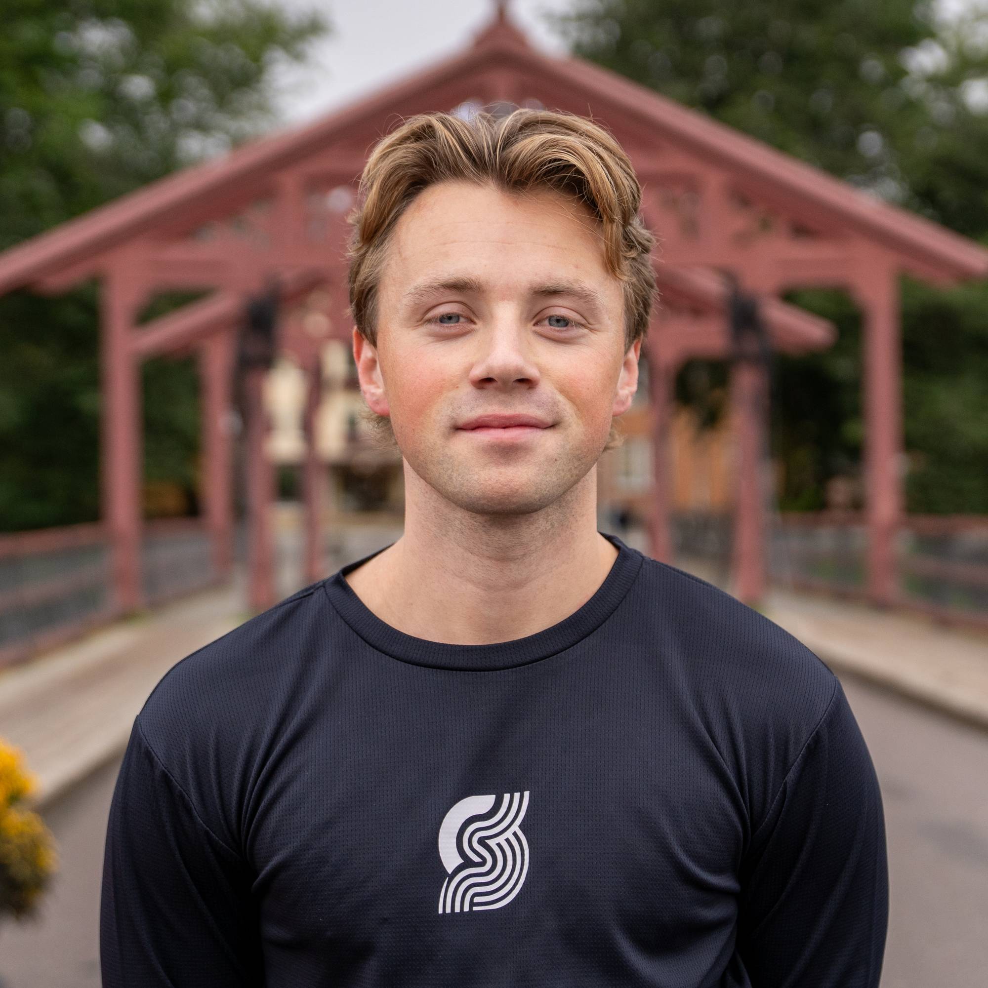 Odin Sørensen Tranås står på Gamle bybro i Trondheim i treningsklær og ser inn i kamera.