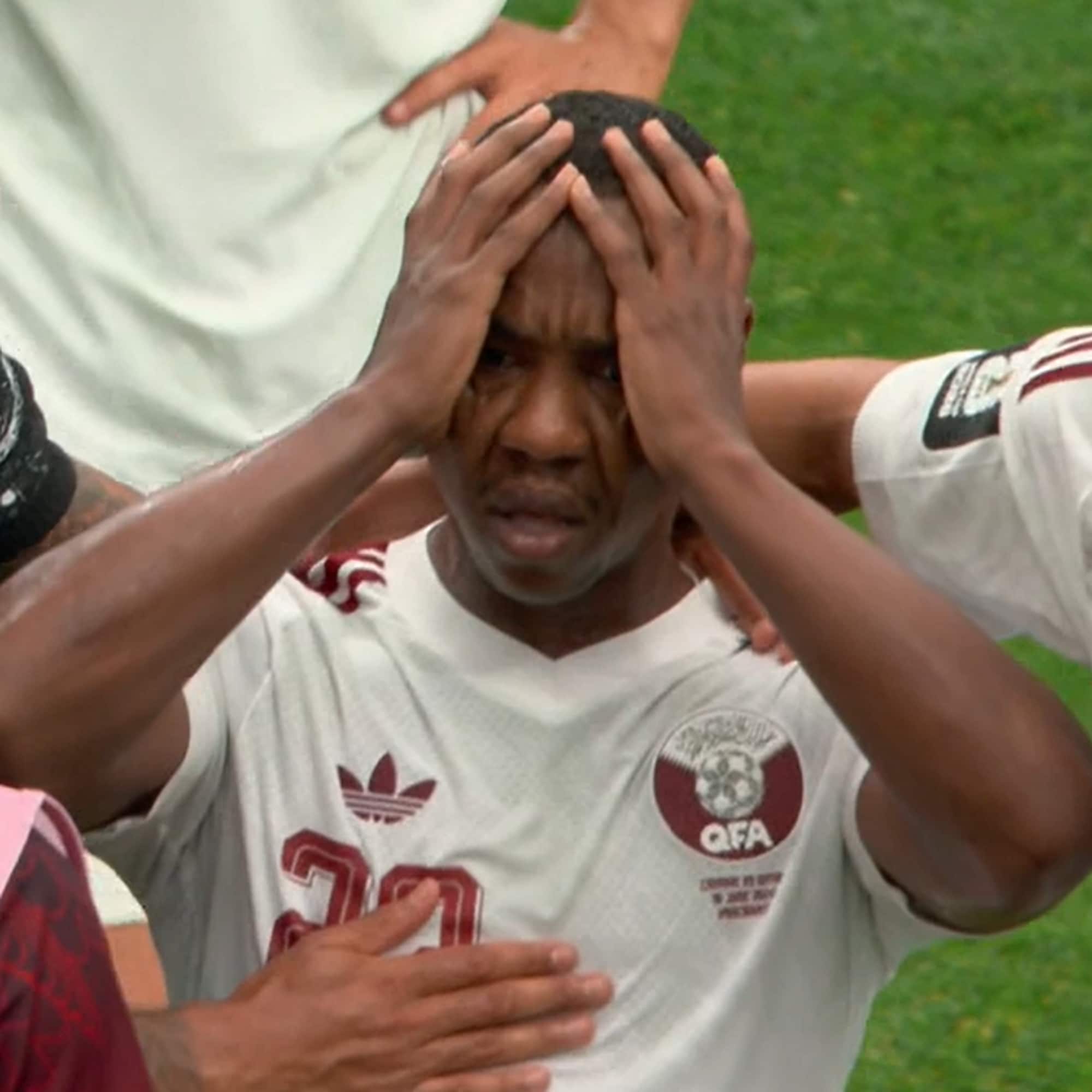Fotballspiller holder hendene i ansiktet