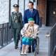 Heiko Junge / NTB Prinsesse Astrid sitter i rullestol med hunden Wilma på fanget og trilles av kong Haralds privatsekretær, ved siden av går en adjutant.