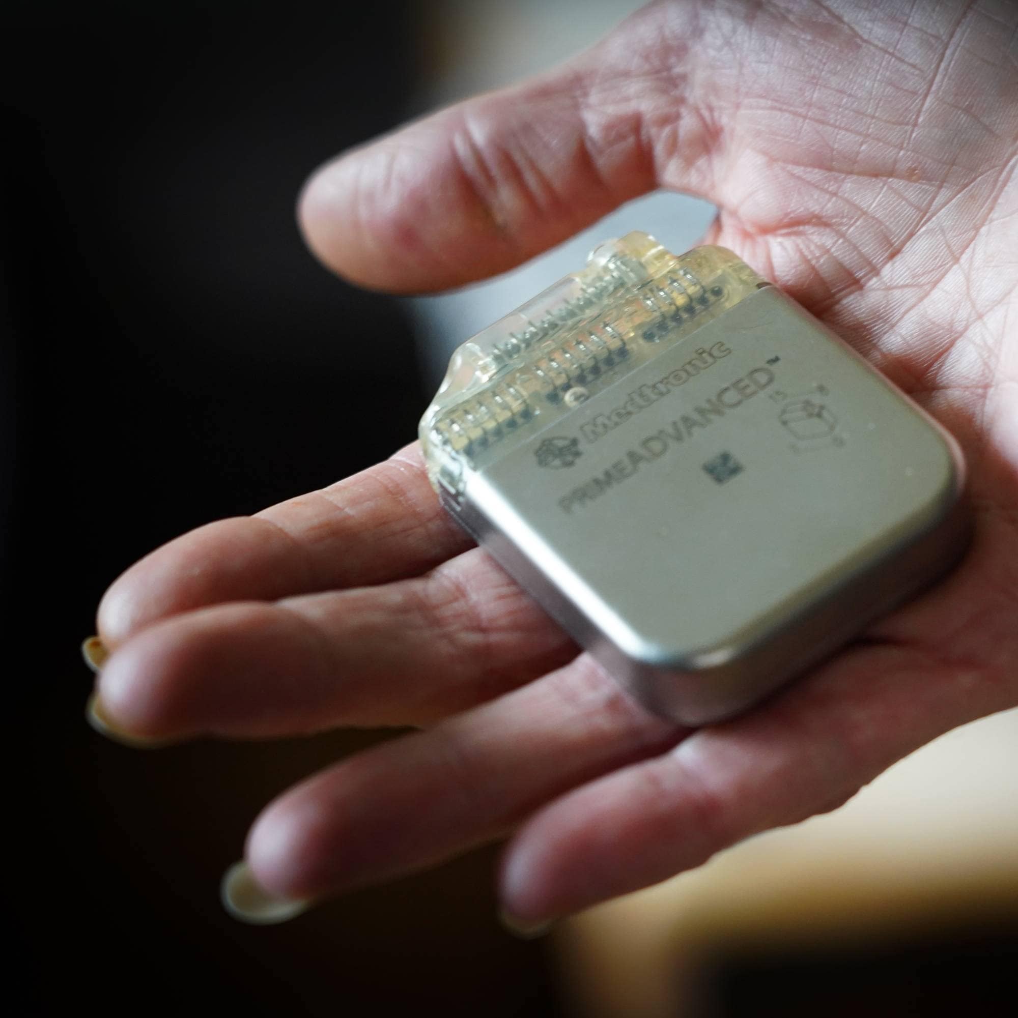 En hånd som holder et firkantet batteri