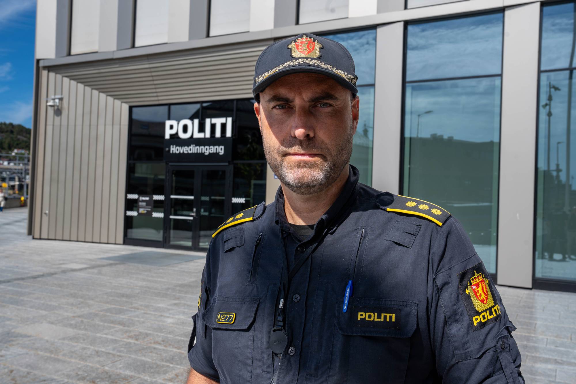 viser en mann i politiuniform utenfor et politihus