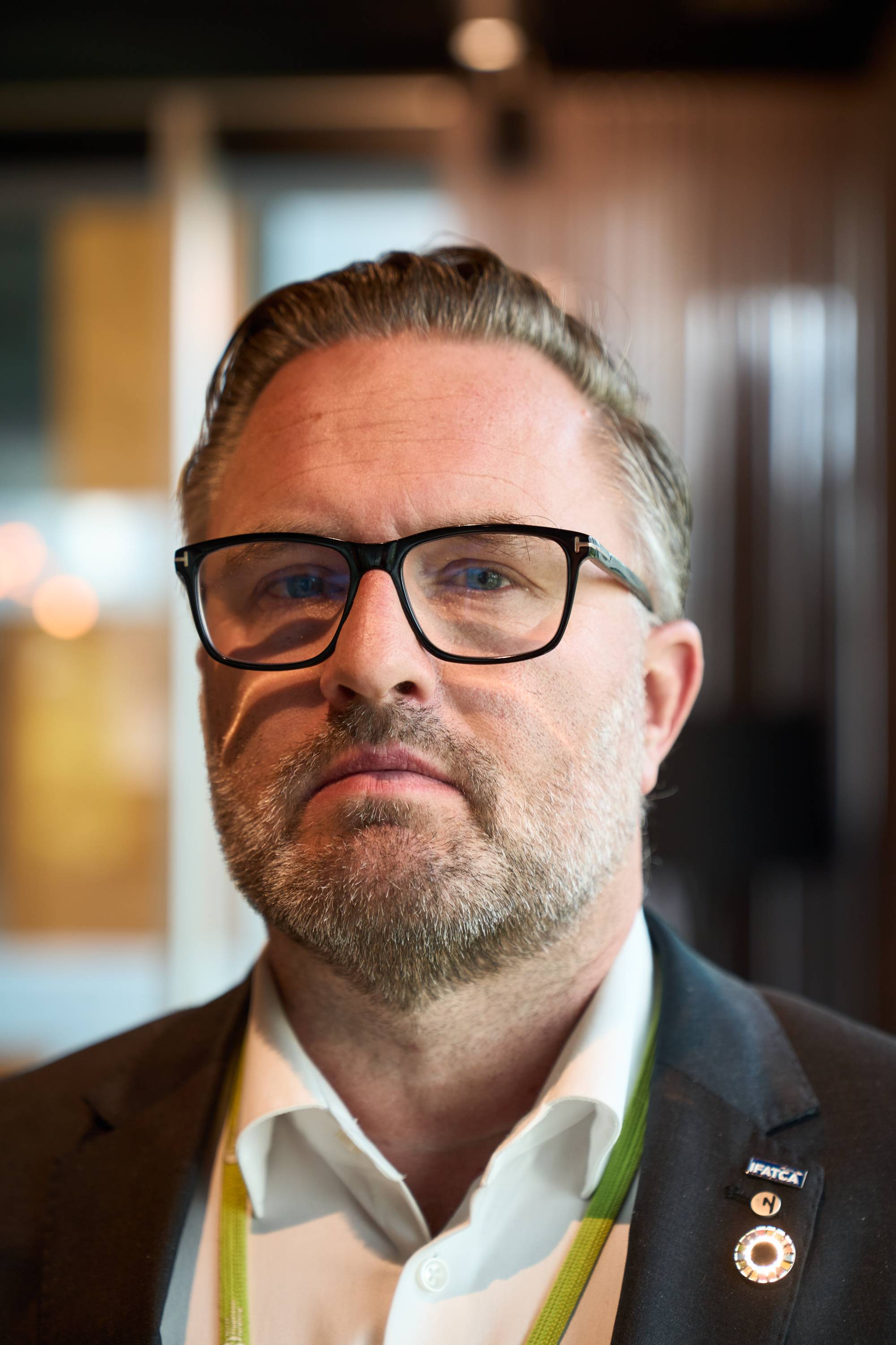 Portrett av en mann med skjegg og briller, ikledd dressjakke og skjorte. (Bildebeskrivelsen er laget av en KI-tjeneste)