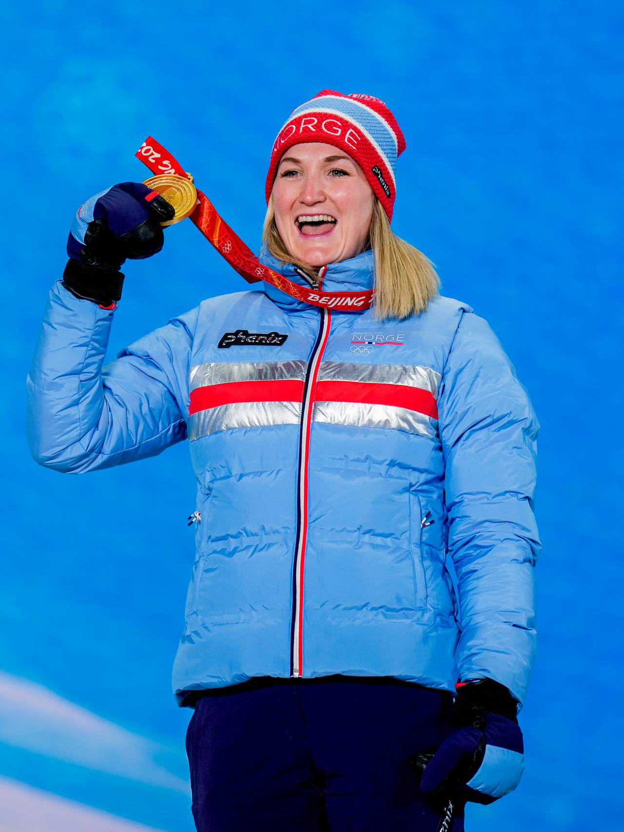 Marte Olsbu Røiseland mottar gullmedaljen etter sprinten i OL i Beijing. 