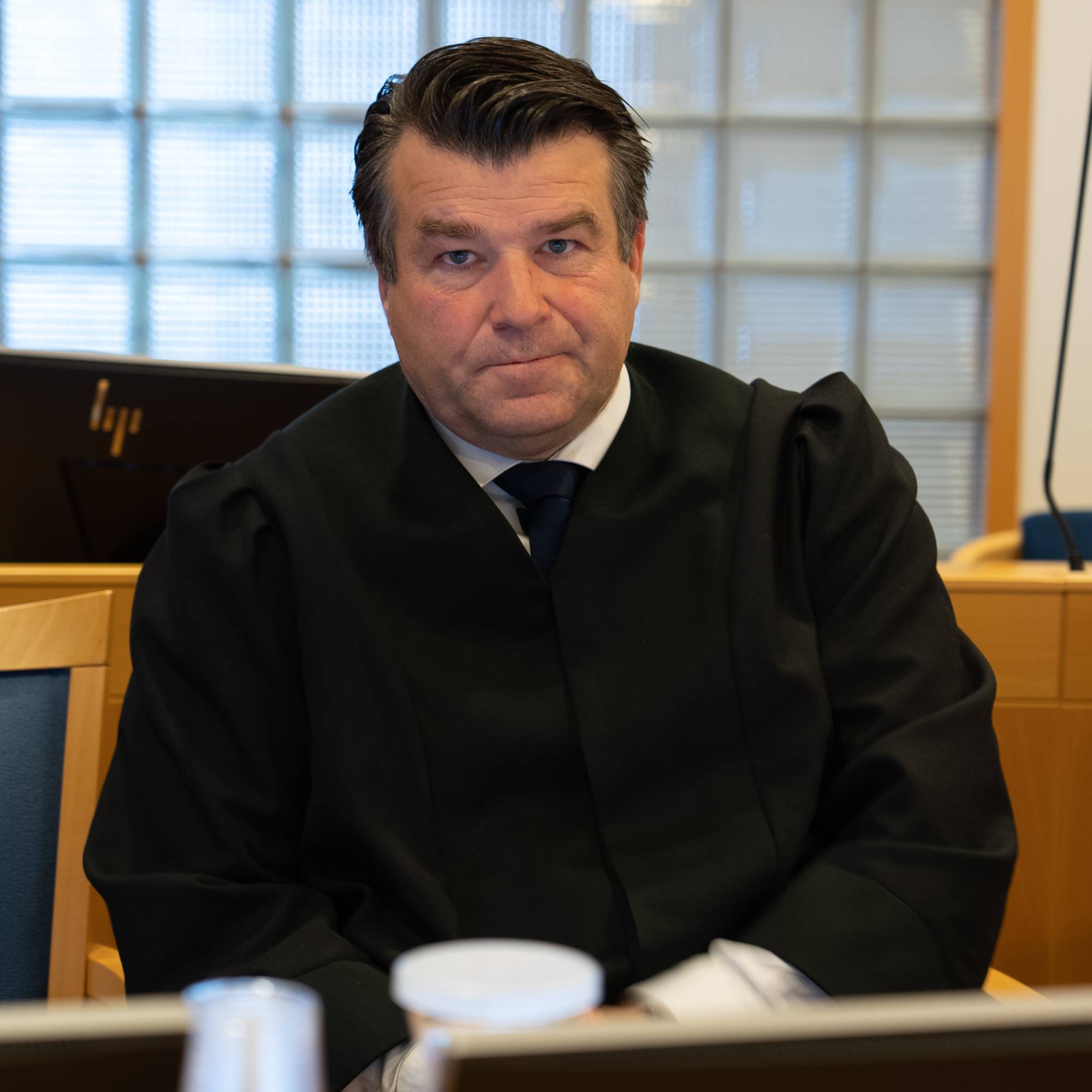 Knut-Erik Storlykken Søvik sitter ved et bord i en rettssal. Han har på seg en svart rettskappe.